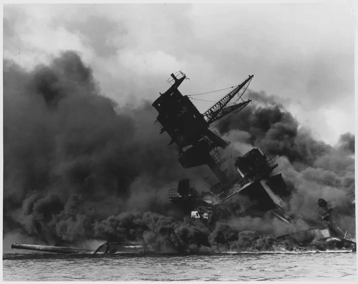 USS Arizona burning during the 1941 attack, the history behind every Pearl Harbor tour