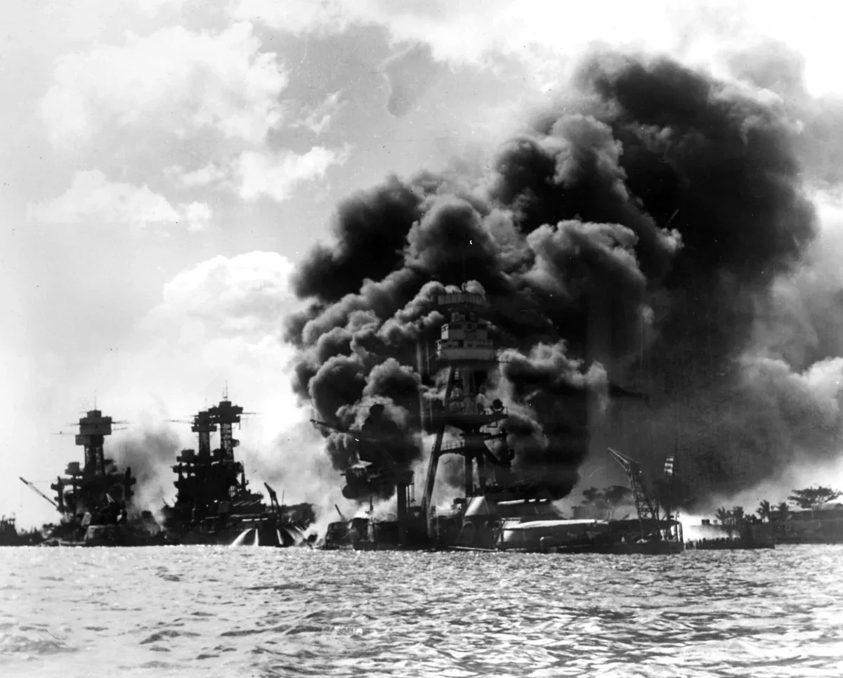 Battleship Row burning on 7 December 1941, the site covered on Pearl Harbor tours from Honolulu